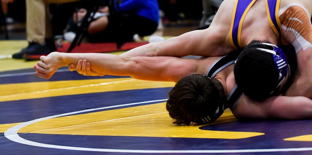 A Hickman wrestler stretches his opponent's arm